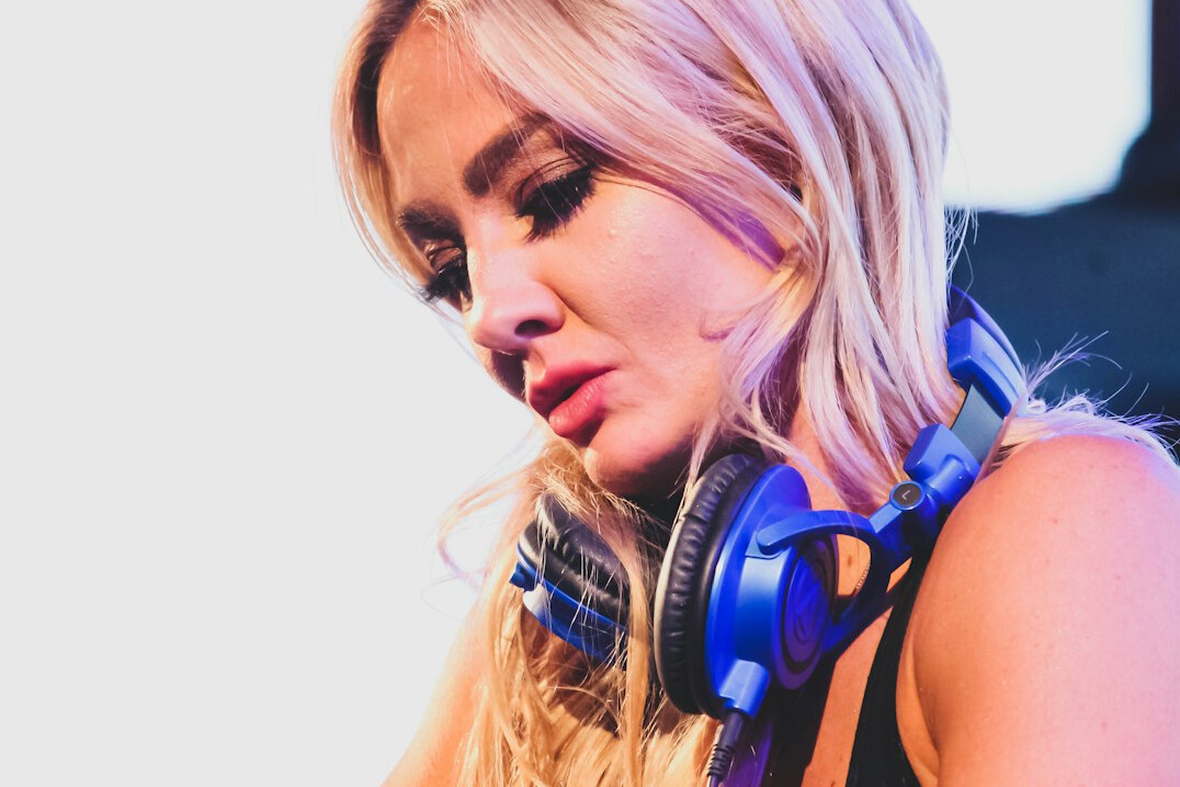 Studio portrait of a woman host wearing headphones in front of a microphone