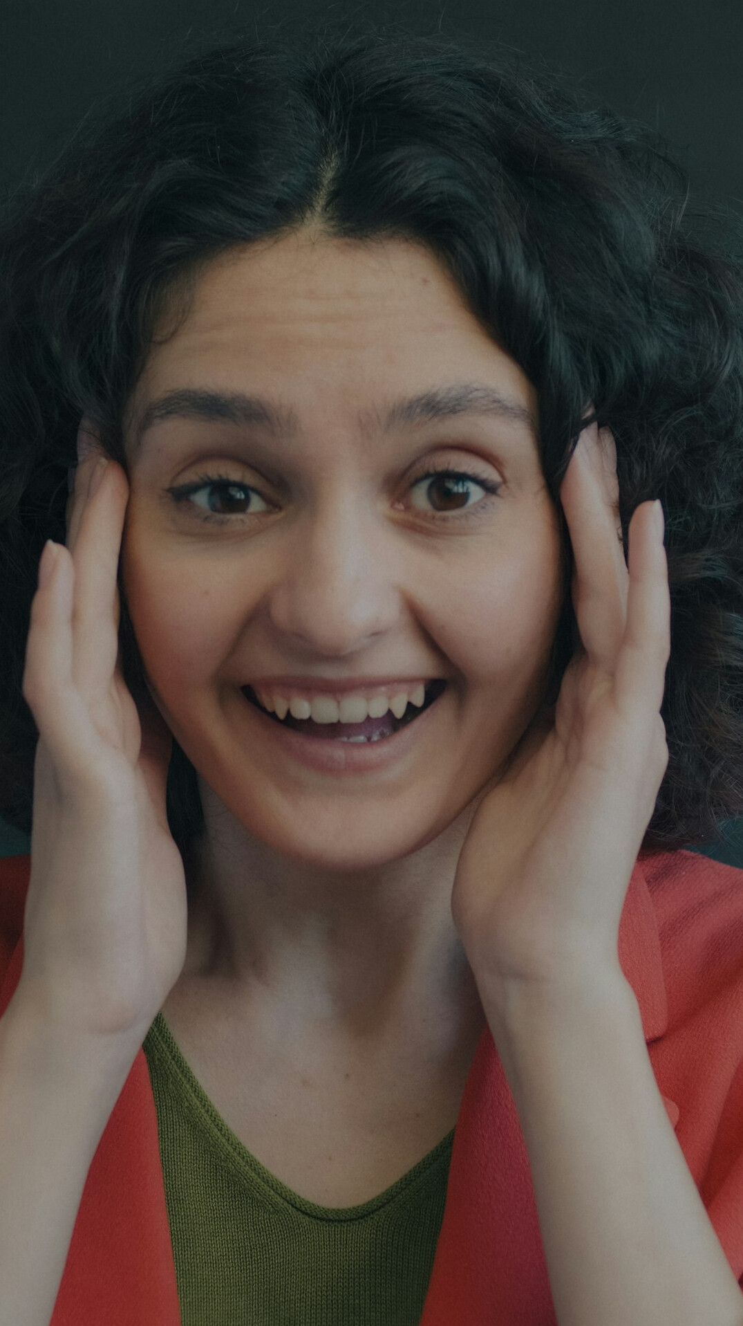 Studio portrait of a young woman with curly hair smiling